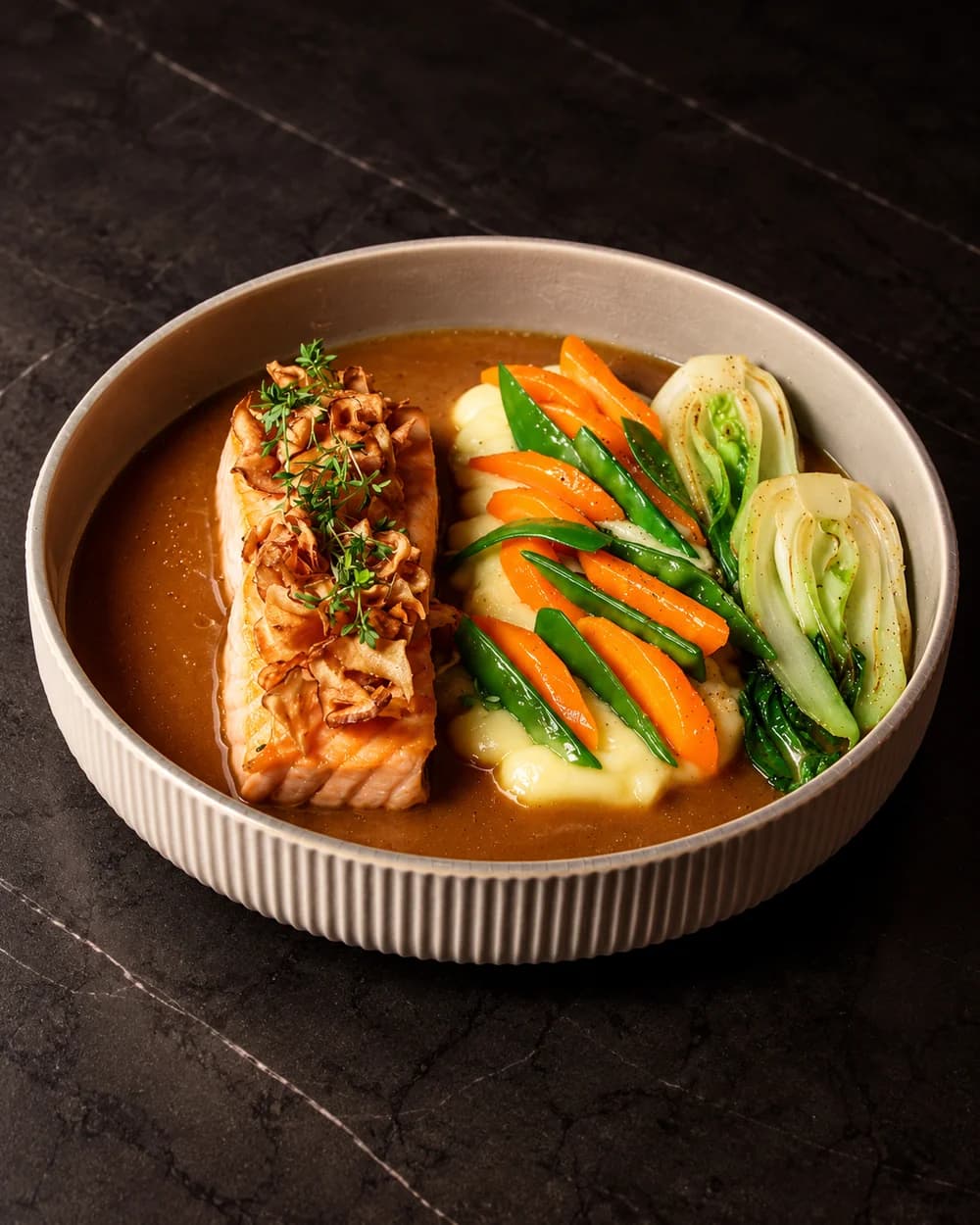 Salmon with honey-soy sauce, mashed potatoes and vegetables in a ceramic bowl
